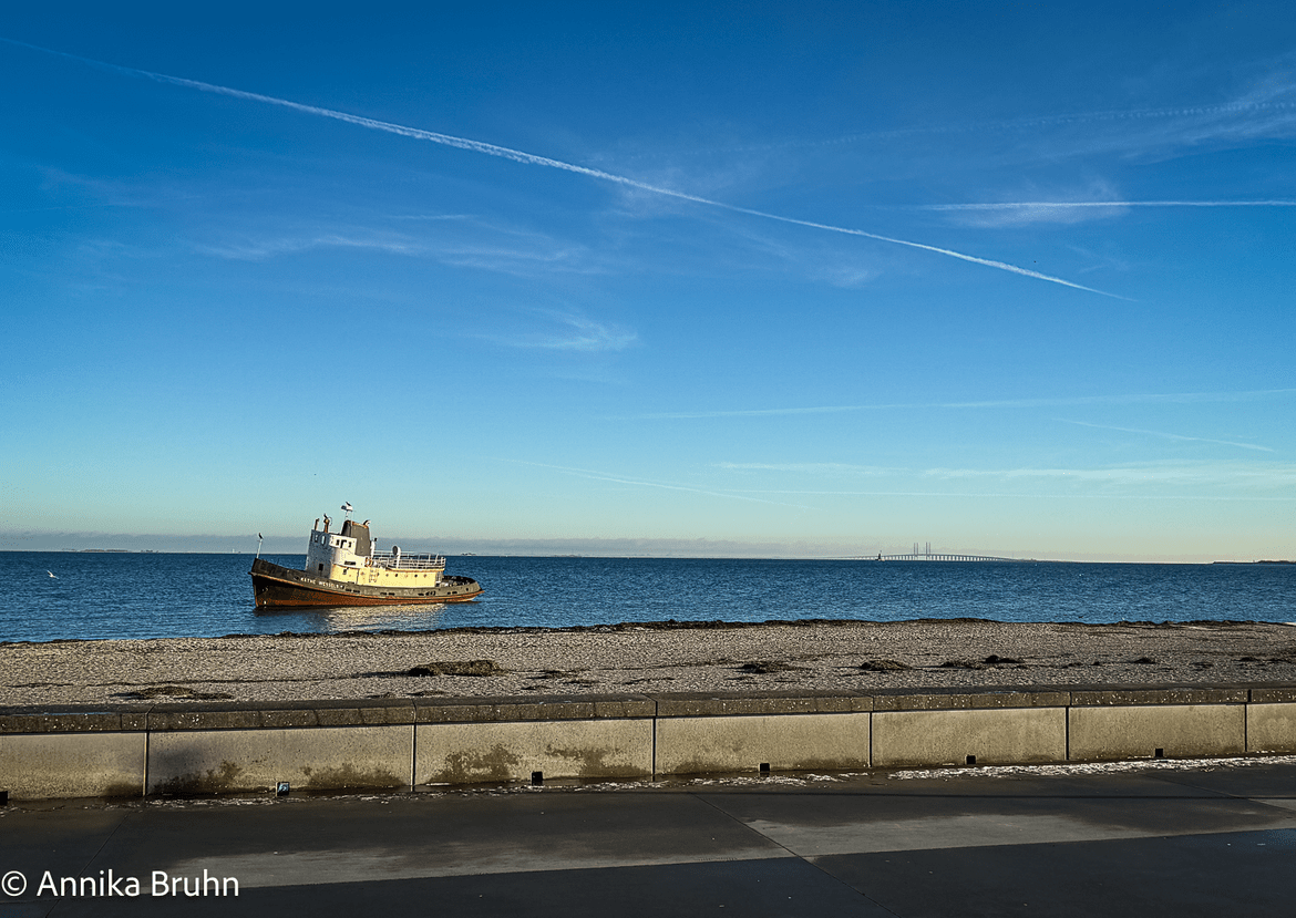 Gestrandetes Boot im Rücken die Öresundbrücke